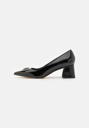Décolleté in vernice nera con punta affusolata e tacco a blocco chunky. Presenta un accento decorativo sulla punta e una superficie liscia e lucida.