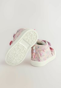 Pink højtop sneakers i stof med blomster mønstre, Velcro remme og en hvid gummisål med et kaninprint på sålen.