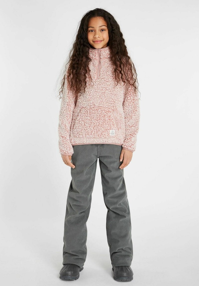 Rosa, flauschiger Fleece-Pullover mit halbem Reißverschluss und Fronttasche, kombiniert mit grauen Cordhosen. Das Outfit zeichnet sich durch eine lässige Passform und strukturierte Stoffe aus.