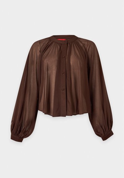 Blouse longue marron transparente à manches longues, épaules froncées, fermeture boutonnée devant, col rond et poignets élastiques sur fond uni.