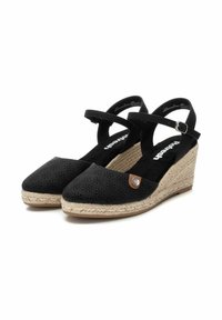 Espadrilles noires à talons compensés avec un dessus perforé, un accent marron et une plateforme en jute tressé. Présentent une bride de cheville et une semelle rembourrée.