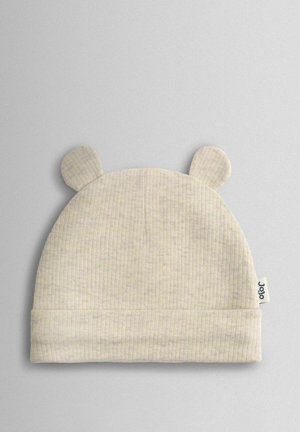 Šiltas smėlio spalvos mezgimo kepurė su ribotu raštu, viršuje turi dvi apvalias meškutės auseles. Šone yra mažytė prekės ženklo etikėtė.