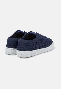 Sneakers in rete blu navy con suole bianche maculate. Presentano un design a profilo basso e un tessuto testurizzato per la ventilazione. Tacco rinforzato.