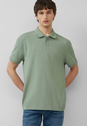 Polo de manga corta en un color verde apagado, con un cierre de tres botones y una textura suave, similar al algodón.