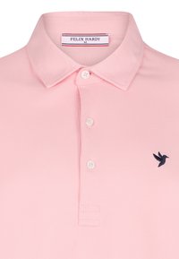 Heled roosa polo särk klassikalise kraega, kolme valge nööbiga ja vasakul küljel tumesinise brodeeritud linnu logoga. Tekstuuriga kangas.