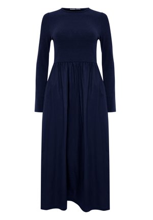 Navyblaues Kleid mit langen Ärmeln, engem Strickoberteil und gerafftem, fließendem Rock, der bis zur Mitte der Wade reicht.