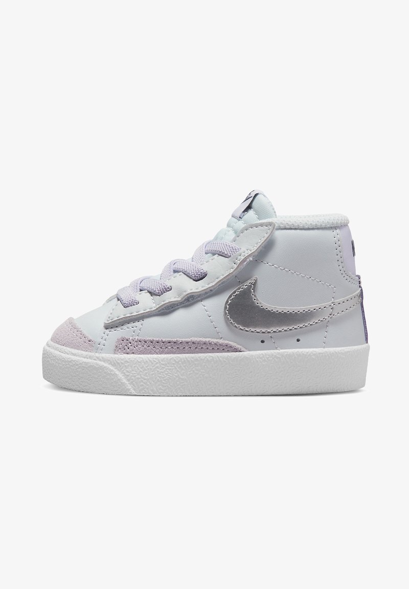 Baskets blanches mi-hautes avec lacets lavande, embout en daim, semelle blanche texturée et logo Nike en métal argenté sur le côté.