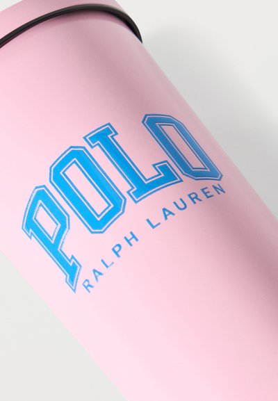 Ροζ κυλινδρικό μπουκάλι με μπλε λογότυπο "POLO RALPH LAUREN" σε μεγάλα, έντονα γράμματα και ασημένιο καπάκι.