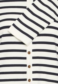 Triibuline kardigan, millel on valge ja mereväe sinine värv, kootud tekstuur, pika varrukaga, esiosal nupud ja klassikalise kraega disain.