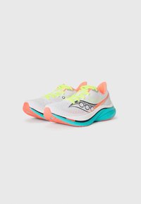 White running shoes with neon green laces, orange soles, blue midsoles, and a black logo on the side, positioned side by side on a white background.