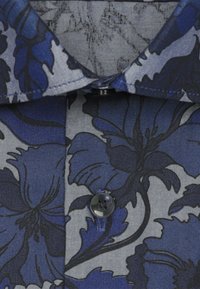 Chemise à manches courtes fleurie avec des motifs bleus et gris. Présente une fermeture à boutons et un col classique, confectionnée en tissu léger.