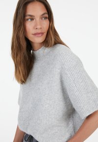Light gray ribbed knit sweater with a mock neckline and short sleeves, featuring a soft texture and relaxed fit.