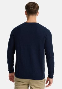 Camicetta a maniche lunghe blu navy realizzata in tessuto morbido, con scollatura rotonda e orlo inferiore dritto con polsini a coste.