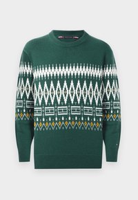 Green knit sweater featuring geometric white and yellow pattern, round neckline, and ribbed cuffs and hem.