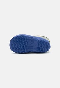 Suela de zapato de goma con un patrón texturizado en zigzag. Color azul con un acabado suave y ligera curvatura en los bordes.