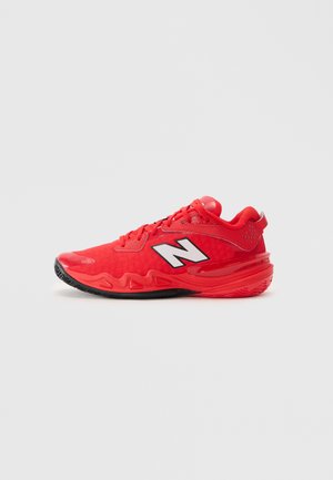 Røde atletiske sneakers med sort sål, snørebånd og et hvidt "N" logo på siden, præsenteret på en ensartet lys grå baggrund.