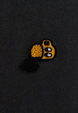 Black fabric with fine vertical ribbing features an embroidered yellow and black cartoon-style bee design, showcasing texture and detail.