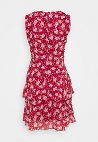 Robe fleurie rouge avec volants en cascade, présentant un design sans manches et une fermeture éclair dans le dos. Les fleurs sont de couleurs rose et crème.