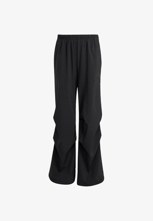Black athletic pants featuring a wide, loose fit with a layered design, elastic waistband, and minimal branding on the side.