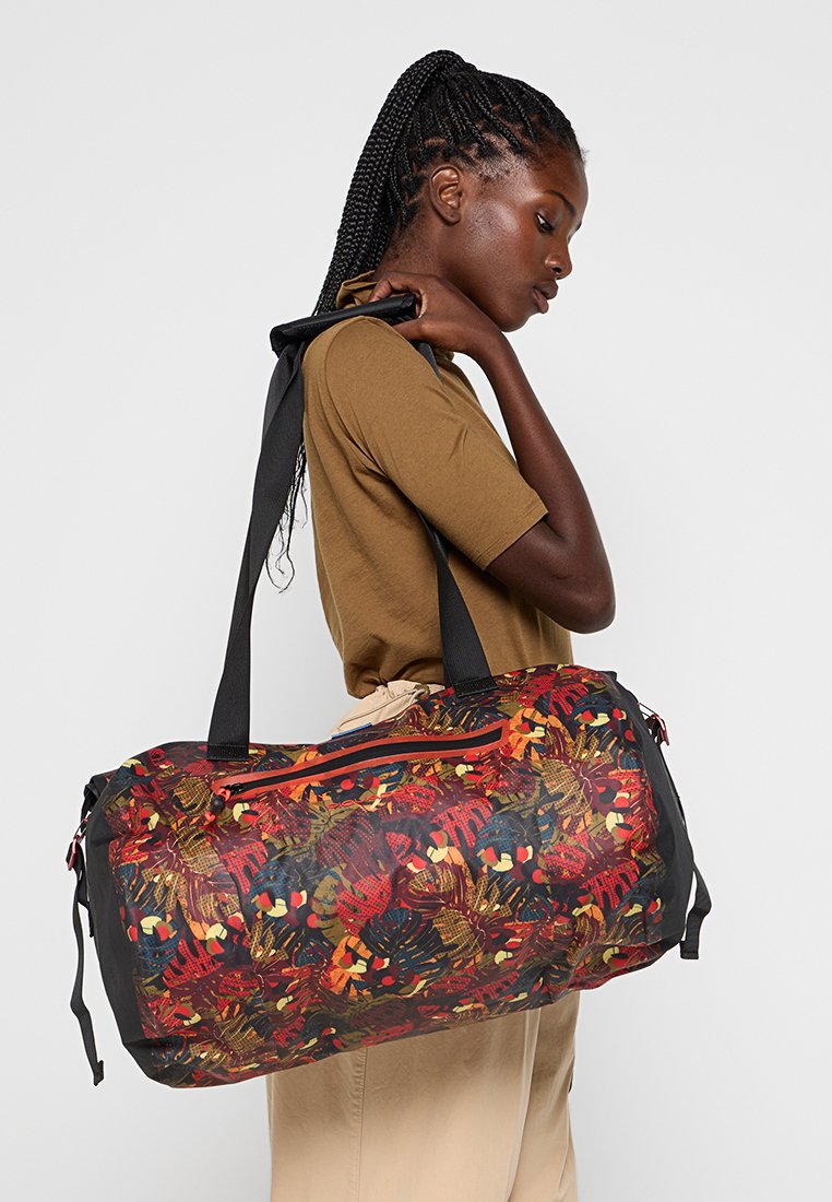 Borsa a tracolla con un motivo floreale rosso, nero e multicolore. Realizzata in tessuto resistente, dotata di una tasca con cerniera e spallacci regolabili.