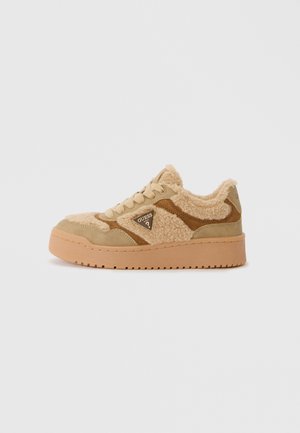 Beige suède sneakers met fluffy stof, voorzien van een driehoekig logo, ronde neus en dikke rubberen zool. Geaccentueerd met donkere tinten.