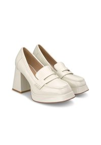 Mocassins en cuir verni blanc avec un épais talon carré. Présentent un panneau avant surélevé et des détails de couture subtils. Texture lisse avec une finition brillante.