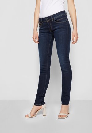 Jeans ajustados de color azul oscuro, hechos de denim con una textura suave, que cuentan con un cierre de botón, cinco bolsillos y sutiles detalles en hilo dorado.