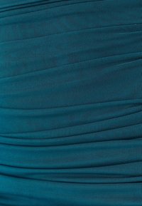 Teal textured fabric with pleated design, featuring horizontal lines and a smooth surface, ideal for clothing or upholstery applications.