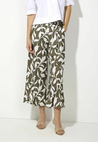 Wide-leg pants in olive green with a white leaf pattern; made of soft fabric; includes a side tie detail and front pockets.