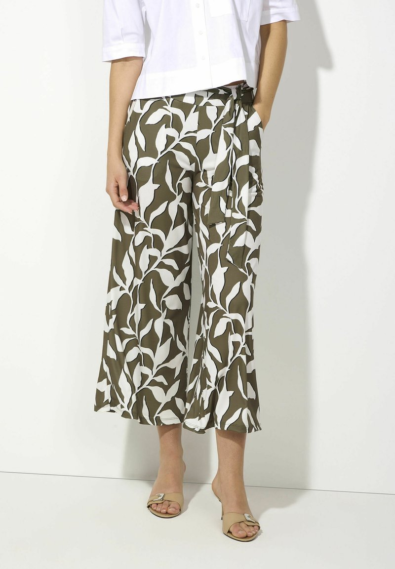 Wide-leg pants in olive green with a white leaf pattern; made of soft fabric; includes a side tie detail and front pockets.