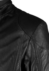 Zwarte leren jas met een gladde textuur, perforaties op de schouders, hoge kraag en gestikte naden voor structurele integriteit.