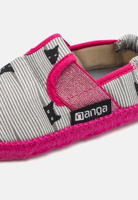 Auduma slip-on kurpes ar pelēku un baltu svītrainu rakstu un melna kaķa motīviem. Spilgti rozā akcenti un teksturēta zole.