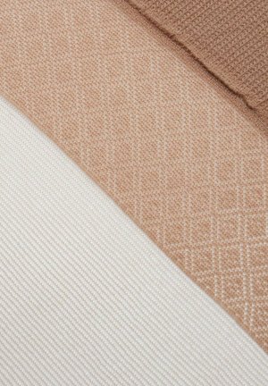 Zbliżenie beżowych i kremowych próbek tkanin o wyraźnych tkanych fakturach i wzorach, ułożonych diagonalnie.