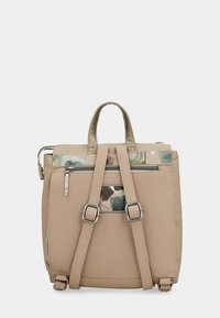 Mochila de cuero beige con correas ajustables, asa superior y un bolsillo trasero con cremallera que presenta un pequeño detalle de parche abstracto colorido.