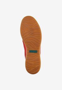Scarpa rossa con suola in gomma marrone testurizzata caratterizzata da motivi a onda, contrassegnata con "37" e "Josef Seibel" in verde.