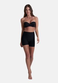 Zwarte strapless beha en high-waisted shorts van een gladde stof, ontworpen om aansluitend te zijn en een naadloze silhouet te bieden.