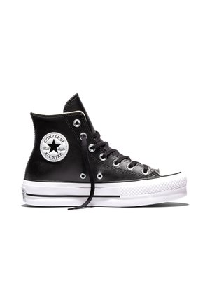 Black leather high-top Converse sneaker with white rubber sole, black laces, and circular white logo patch on ankle.