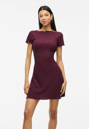 Robe courte bordeaux avec un tissu texturé, des manches courtes, un décolleté en scallop et une silhouette ajustée, se terminant au-dessus des genoux.