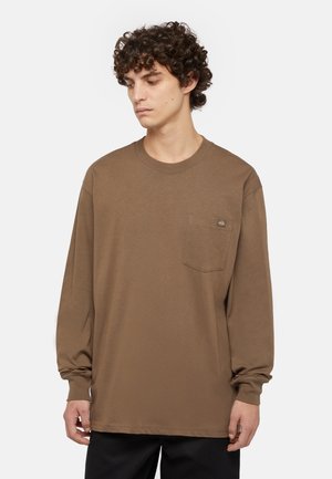 Camisa marrón de manga larga hecha de un tejido suave, con un bolsillo en el pecho y un escote redondo, y mangas ligeramente holgadas.