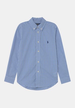Chemise à carreaux bleus et blancs à manches longues avec boutons, col et petit logo brodé sur la poitrine gauche.