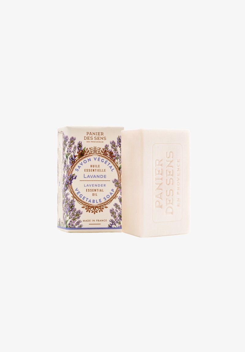 Lavender vegetable soap bar next to floral packaging with "Panier Des Sens" branding and lavender illustrations, made in France.