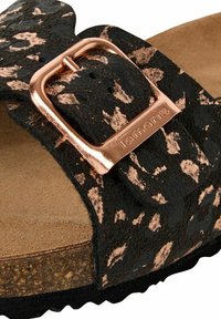 Sandal en suède noir avec imprimé léopard, présentant une boucle en or rose et un semelle intérieure texturée, monté sur une semelle en liège.
