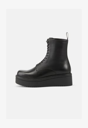 Botas de tornozelos em couro preto, com atacadores na frente, ponta arredondada e sola de plataforma robusta com padrão em zigue-zague para melhor aderência.