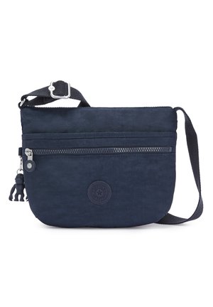 Navy blue crossbody bag made of durable material with adjustable strap, front zip pocket, and rubber logo detail. Features a monkey keychain.