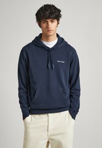 Sudadera azul marino de algodón, con un bolsillo frontal, capucha con cordón y un logo blanco de "Pepe Jeans" en el pecho. Textura suave.