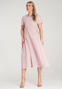 Helles pinkes Leinenkleid mit kurzen Ärmeln, rundem Ausschnitt und seitlichen Bindebändern zur Anpassung, fließende Silhouette mit einem knielangen Saum.