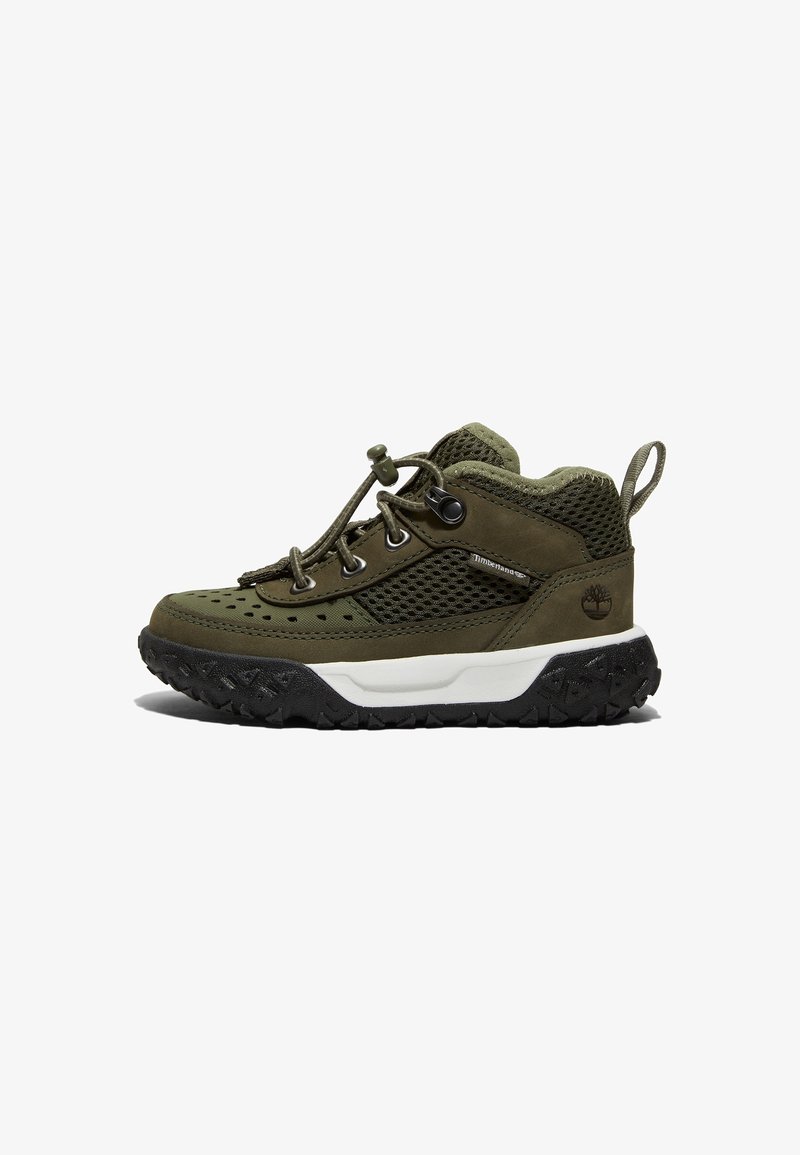 Chaussure de randonnée pour tout-petit vert et noir avec côtés en mesh, lacets à bouton-pression, semelle intermédiaire blanche et semelle extérieure noire robuste, vue de côté sur fond blanc.