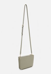 Zielona torebka crossbody z sztucznej skóry o płaskim kształcie, z regulowanym paskiem i złotymi akcentami. Zamek błyskawiczny na górze, gładka faktura.
