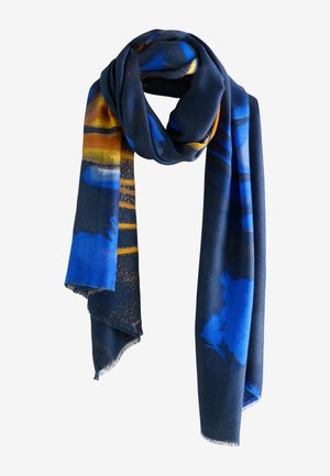 Écharpe bleu foncé avec des motifs abstraits en bleu vif, orange et jaune, suspendue avec des bords à franges.