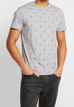 Graues Baumwoll-T-Shirt mit kurzen Ärmeln, das ein wiederholendes schwarzes geometrisches Muster aufweist. Der Stoff ist glatt und die Passform ist lässig.